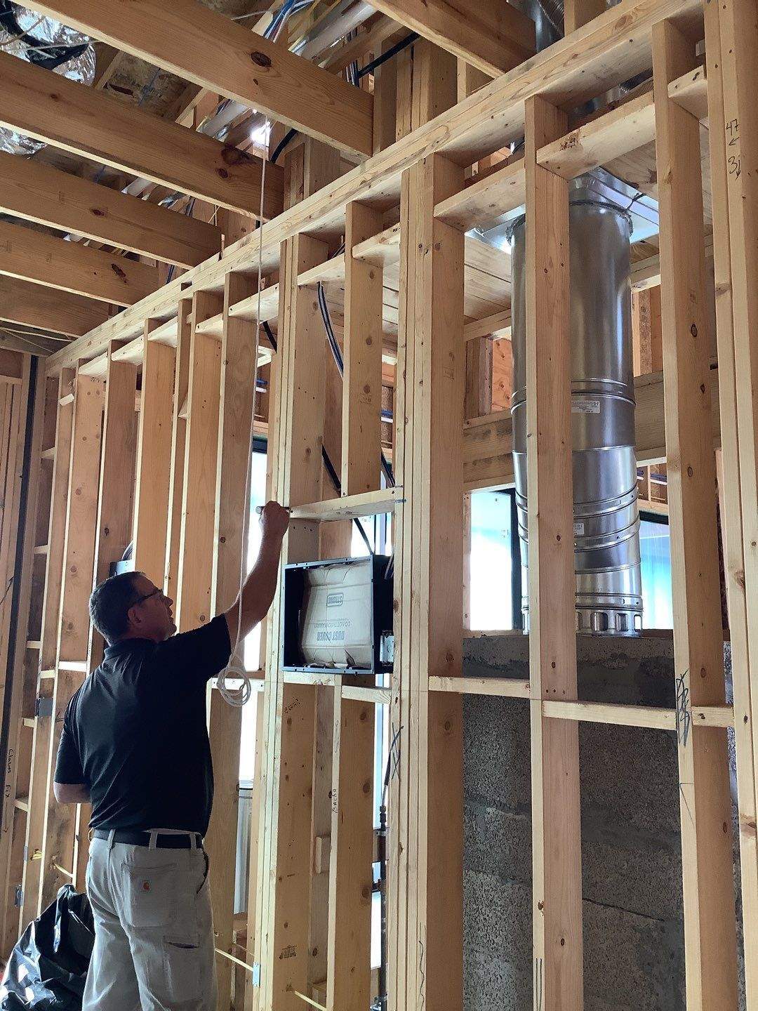 Field observer reviewing exposed wall framing